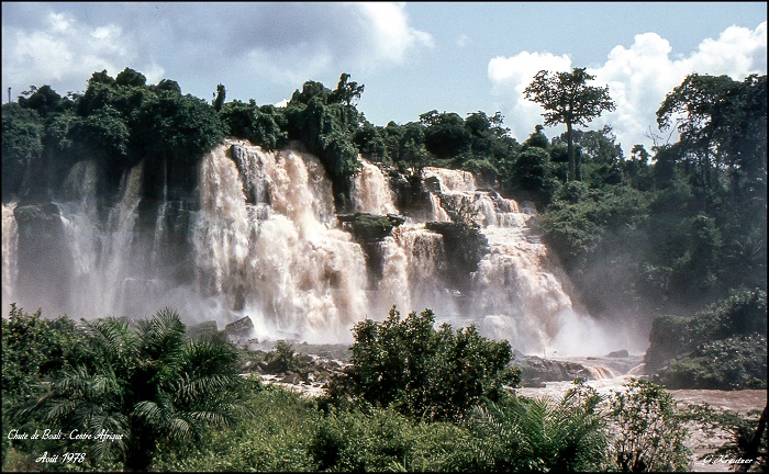 This is a photo of the Chute de Boali waterfall in Central African Republic, taken in August 1978, showing cascading water surrounded by lush vegetation.